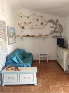 ein Wohnzimmer mit einem Sofa und einem Tisch in der Unterkunft Casa Gaia comoda e accogliente in Costa Paradiso