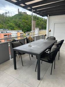 a black table and chairs on a balcony at LiT LiVING: Luxury - Box Spring - große Terrasse - bbq - sagenhafte Aussicht in Weinheim
