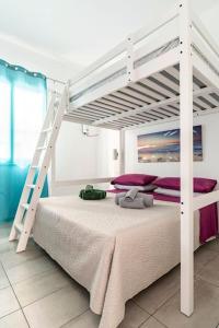a bedroom with a white bunk bed with a ladder at Casa Gioia in Giardini Naxos