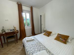 a bedroom with a bed and a desk and a window at La naronne in Bandol