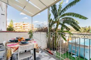 a table on a balcony with a view of a pool at Casa Gioia in Giardini Naxos