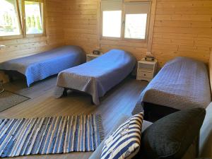 Habitación con 2 camas en una cabaña de madera en Ranna majutus, en Pärnu