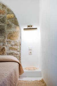 um quarto com uma cama e uma parede de pedra em Anesis Traditional Rhodian House em Kattavía