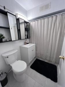 a white bathroom with a toilet and a shower at Good Old Days Main Retro in Vancouver