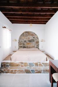 uma cama num quarto com uma parede de pedra em Anesis Traditional Rhodian House em Kattavía