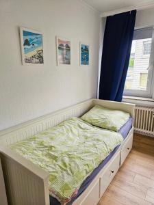 een klein bed in een slaapkamer met een raam bij 3 Zimmer Apartment in Wuppertal