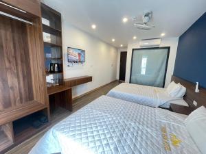 a bedroom with two beds and a tv in it at Thanh Nam Hotel in Dong Quan