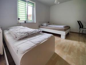 sypialnia z 2 łóżkami i oknem w obiekcie FEWO Jänschwalde II w mieście Jänschwalde Ost