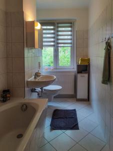 y baño con bañera, lavabo y aseo. en FEWO Jänschwalde II, en Jänschwalde Ost