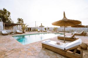 - une piscine bordée de parasols et de chaises longues dans l'établissement Villa Madame Babouche, chambre Tinhinan, SdB privative, à Oulad el Madani