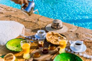 a table with food and drinks next to a pool at Villa Madame Babouche, chambre Tinhinan, SdB privative in Oulad el Madani