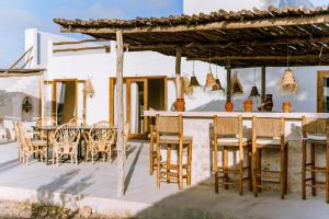 a patio with chairs and tables and a bar at Villa Madame Babouche, chambre Tinhinan, SdB privative in Oulad el Madani