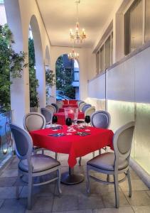 una sala da pranzo con tavolo e sedie rossi di Coelho Boutique Hotel a Gatteo a Mare