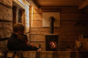 a man and a woman sitting in front of a fireplace at Gemütliche Blockhütte mit Sauna in Jörn