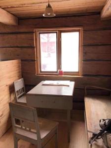 a room with a table and a window in a log cabin at Gemütliche Blockhütte mit Sauna in Jörn