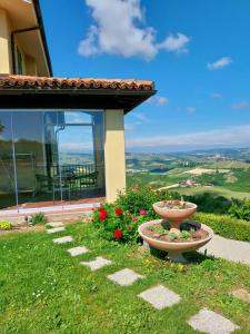 a flower pot sitting in the grass next to a house at Villa Bellavista Alba, B&B in Alba