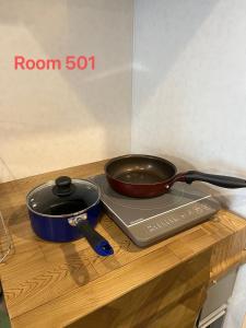 a frying pan and a pan sitting on a table at SkyHotel Ryogoku 駅徒歩4分 in Tokyo