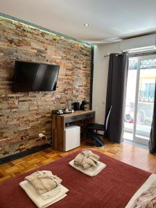 a living room with a brick wall and a tv at AL Barbinha in Faro