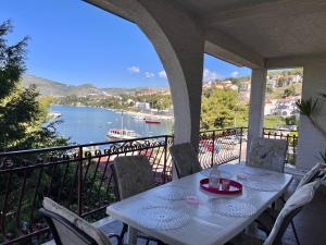 a table on a balcony with a view of the water at Apartments Villa Mirella 20 m from the sea - free parking in Trogir