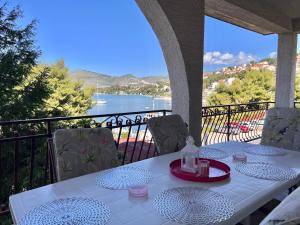a table on a balcony with a view of the water at Apartments Villa Mirella 20 m from the sea - free parking in Trogir