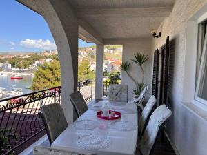 a table and chairs on a balcony with a view at Apartments Villa Mirella 20 m from the sea - free parking in Trogir