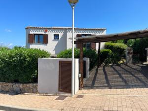 帕勞的住宿－Sardegna home luxury b&b，白色的房子,有门和街灯