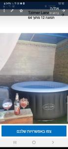 a picture of a hot tub with two glasses of wine at Tzimer Lana in Arad