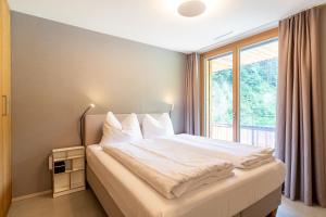 um quarto com uma cama grande e uma janela em Edelweiss Stenna Selva em Flims