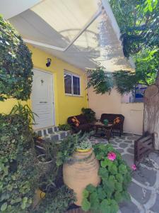 a patio with a couch and flowers in front of a house at Summer studios 1 in Koroni