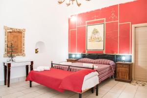 BoscotrecaseにあるVilla Giulia - Vesuvio Guest House Pompei Sorrentoの赤い壁のベッドルーム1室(ベッド2台付)