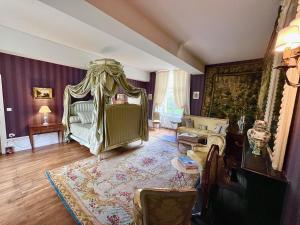 uma sala de estar com uma cama e um sofá em Château de Cadouzan em Saint-Dolay