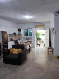 a living room with a couch and a kitchen at Summer studios 1 in Koroni