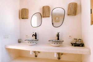 a bathroom with two sinks and two mirrors at Villa Madame Babouche, chambre Taziri, SdB privative in Oulad el Madani