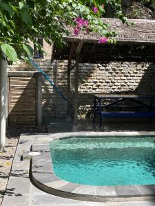 a swimming pool with a hose in front of a building at Elephant House and Bungalows Gili Air in Gili Air