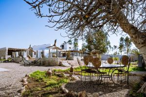 a table and chairs in a yard with a house at Villa Madame Babouche, chambre Taziri, SdB privative in Oulad el Madani