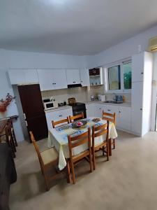 a kitchen with a table and chairs and a kitchen with white cabinets at Summer studios 1 in Koroni