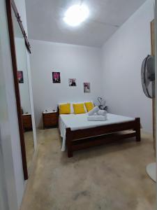 a bedroom with a bed with yellow pillows and a mirror at Summer studios 1 in Koroni