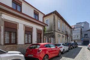Una fila de autos estacionados en una calle de la ciudad en Maria Pia Suite 4 com Terraço, en Oporto