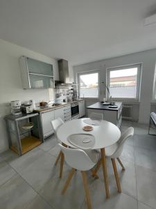 een keuken met een witte tafel en witte stoelen bij City Loft in Freudenstadt