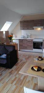 uma sala de estar com uma cozinha com pisos em madeira em Haus Valentin em Dornum