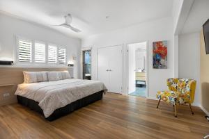 a bedroom with a bed and a chair at Jandar Retreat Maleny in Maleny