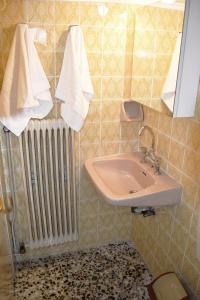 uma casa de banho com um lavatório, um radiador e toalhas em Nicola's House with private parking em Kavala