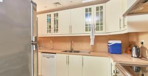 a kitchen with white cabinets and a sink at Great lagoon view 1 bedroom Flat in Ras al Khaimah