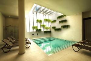 a swimming pool with plants on the wall in a room at Rasim Palas - Adults Only in Cesme