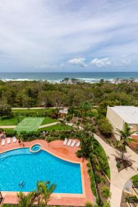 una vista aérea de una piscina y el océano en Marcoola Beach Resort, en Marcoola