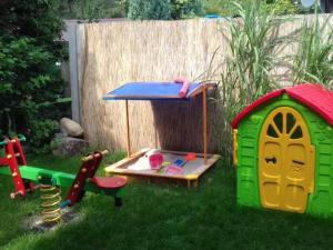a childs play area with a play set in the grass at Apartamenty Żarnowska in Żarnowska