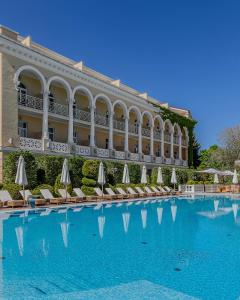 a hotel with a large swimming pool with chairs and umbrellas at Palace Del Mar in Odesa