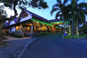 a building with palm trees in front of it at Lombok Garden Hotel in Mataram