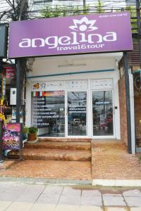 a store with a purple sign on the front of it at Angelina Guesthouse in Patong Beach