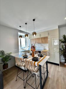 a kitchen with a table and chairs in a room at Apartamento Vista Mar a menos de 50m da praia. in Armação de Pêra